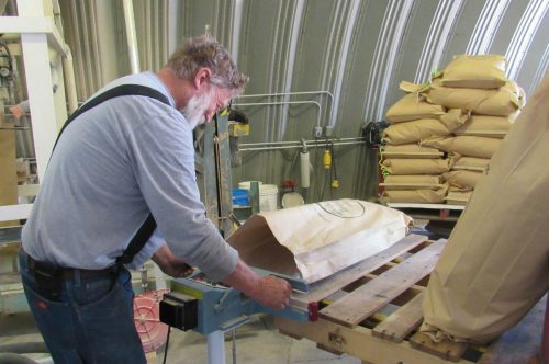 Wayne Cody bags malt for shipment to a distillery in Longmont, Colo. Cody’s grandparents bought the 300-acre farm in the 1930s. Now he and his sons are seeking ways to keep the farm profitable, even as farm incomes erode.