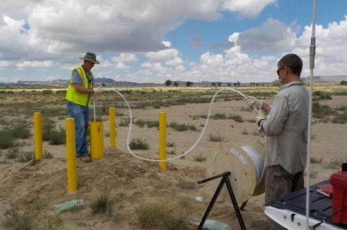 INTERA staff collecting water samples from a groundwater well for contaminant testing and remediation.